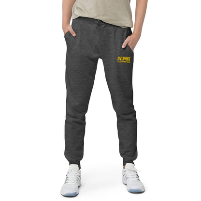 Black unisex fleece sweatpants by DVLPMNT CLOTHING CO. shown on a model, featuring a relaxed fit and comfortable design.